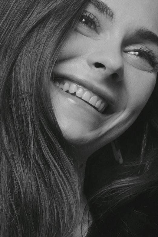 a black and white photo of a woman smiling, inspired by Grethe Jürgens, photorealism, lorde, perfect smile and tooth, head bent back in laughter, close-up shoot