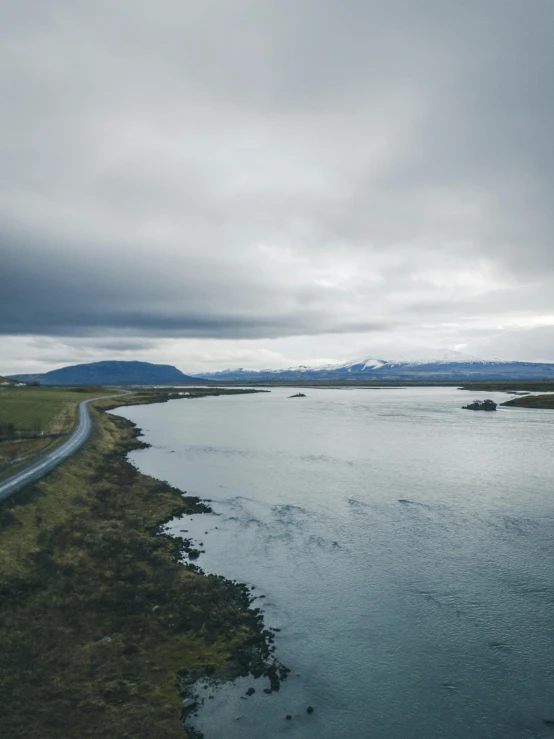 a road that is next to a body of water, inspired by Þórarinn B. Þorláksson, pexels contest winner, hurufiyya, panoramic view, grey, high quality image”