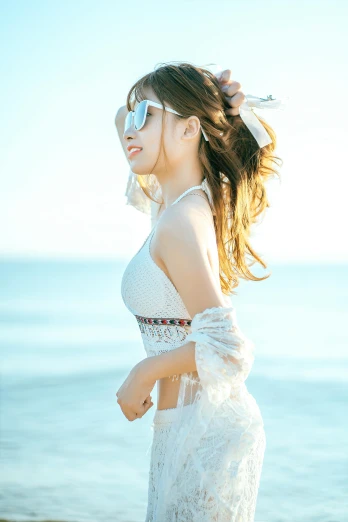 a woman standing on top of a beach next to the ocean, an album cover, inspired by Kim Jeong-hui, gorgeous young korean woman, lace, with sunglass, no cropping