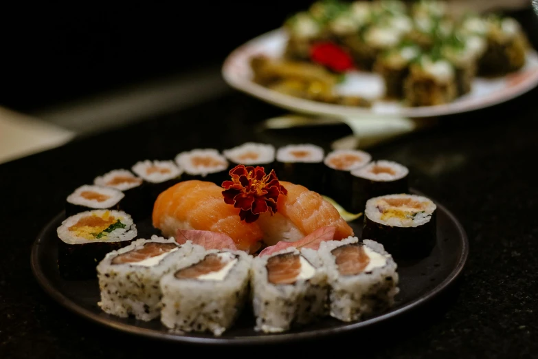 a black plate topped with sushi next to a plate of sushi, by Niko Henrichon, unsplash, mingei, jovana rikalo, high details photo, thumbnail, 90s photo