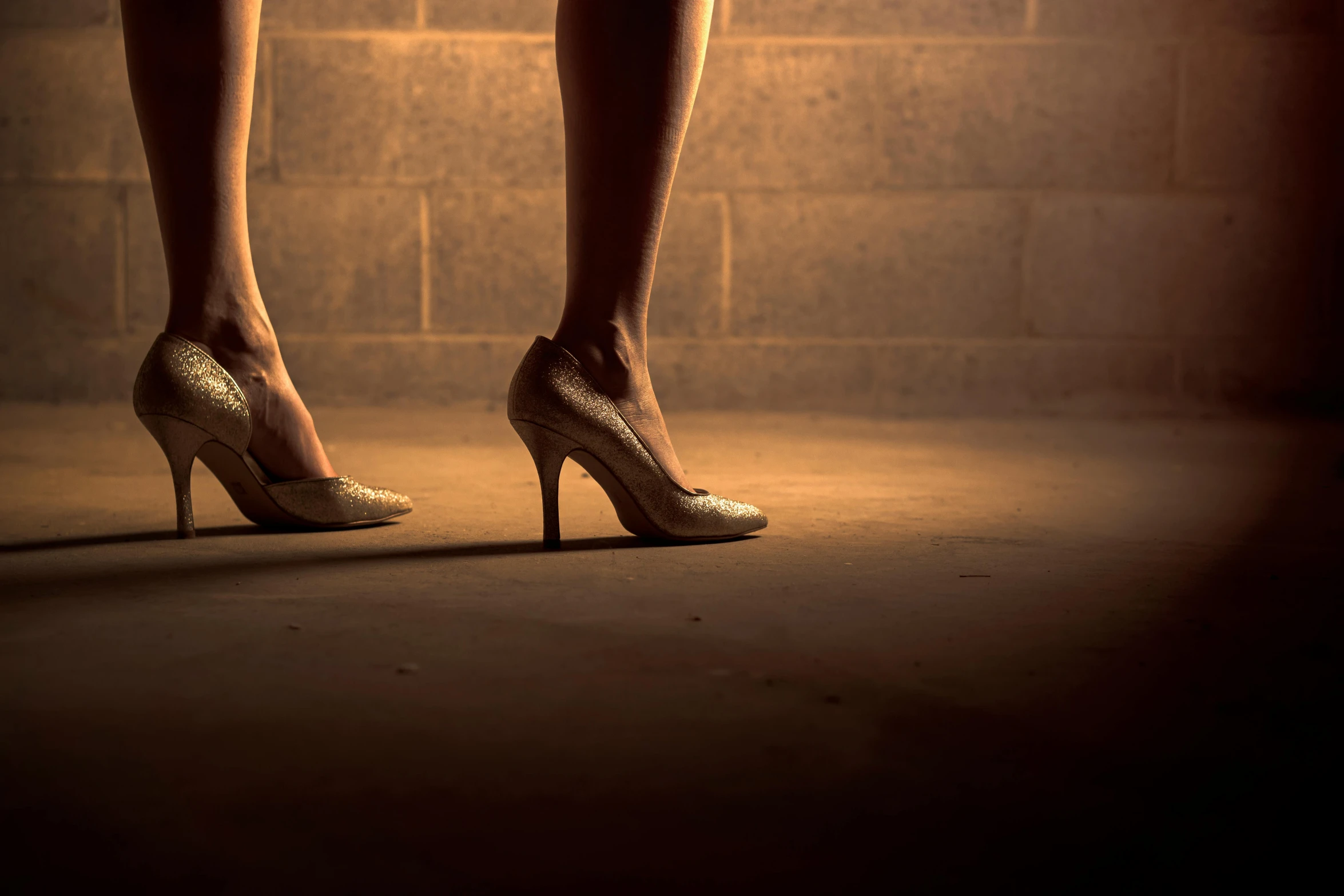 the legs of a woman in high heels, inspired by Nan Goldin, pexels contest winner, renaissance, dimly lit underground dungeon, gold dappled light, standing in an arena, recital