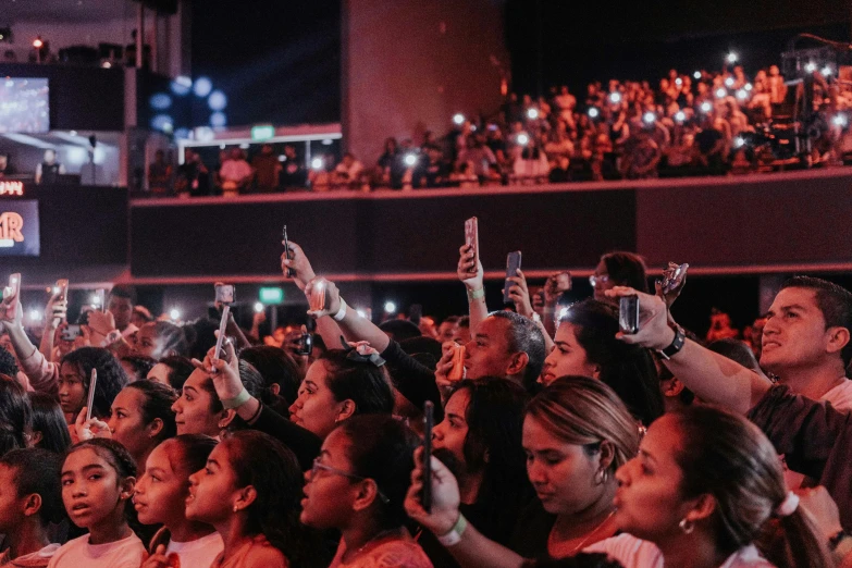 a crowd of people taking pictures with their cell phones, by Robbie Trevino, pexels, 2 rappers on stage at concert, philippines, in an arena pit, looking off to the side