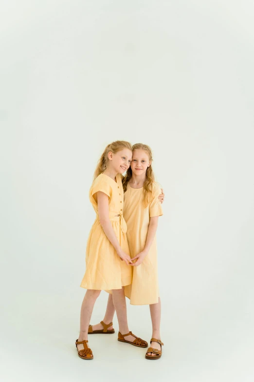 two little girls standing next to each other, by Ellen Gallagher, unsplash, conceptual art, elegant yellow skin, official product photo, young teen, professional studio photograph