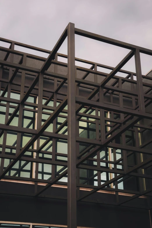 a clock on a pole in front of a building, inspired by Donald Judd, unsplash, brutalism, cages, 3/4 view from below, low quality photo, brown