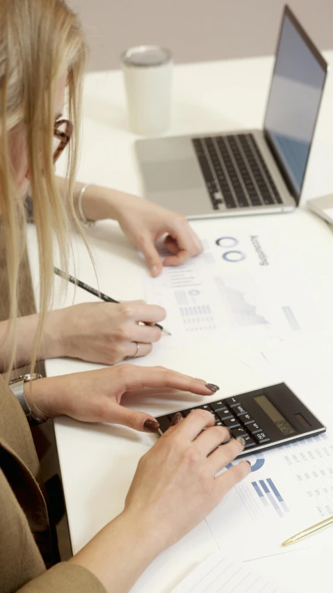 a woman sitting at a table with a laptop and a calculator, pexels, analytical art, 15081959 21121991 01012000 4k, medium close shot, then another, low quality photo