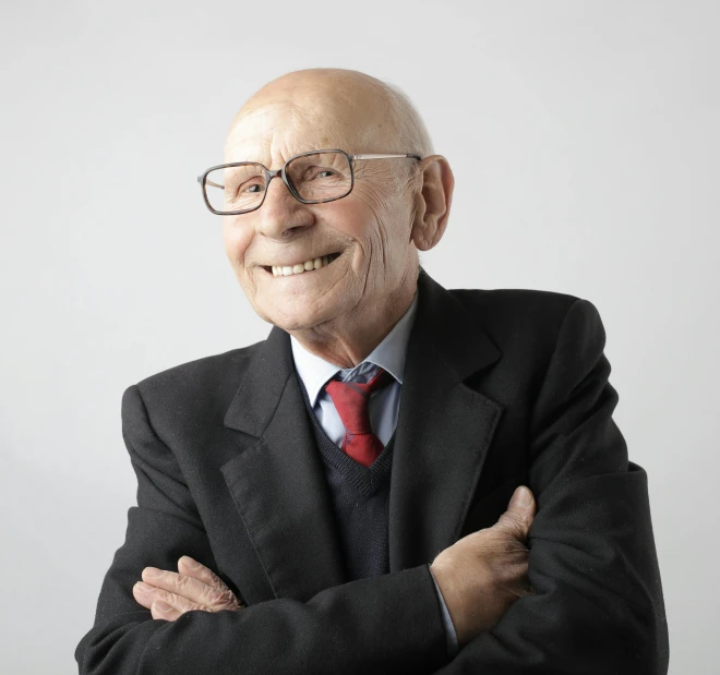 a man in a suit and tie posing for a picture, inspired by Heinz Edelman, an elderly, dieter rams, laughing man, portrait image