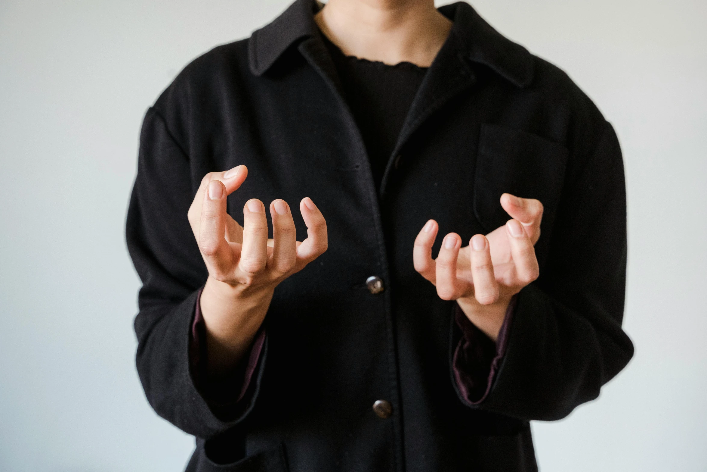 a woman that is standing up with her hands in the air, by Emma Andijewska, visual art, unclipped fingernails, a man wearing a black jacket, spells practice, swollen muscles