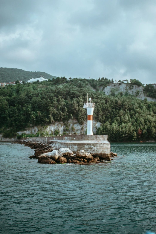 a lighthouse in the middle of a body of water, south korea, color ( sony a 7 r iv, croatian coastline, lush surroundings