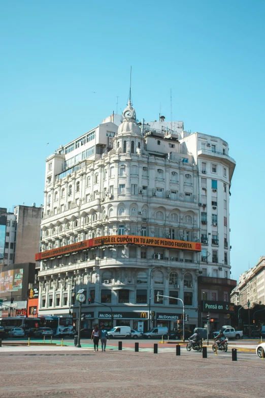 a large white building sitting on the side of a road, inspired by Francisco Zúñiga, art nouveau, buenos aires, low quality photo, madrid, square