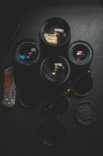 a couple of camera lenses sitting on top of a table, aviators, camera looking up, nighttime photography, flatlay