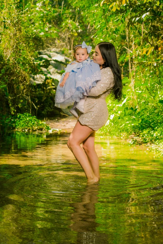 a woman holding a baby in a river, full body photoshoot, lush environment, ready to model, awards winning