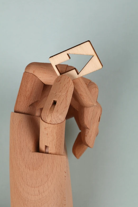 a wooden hand holding a piece of paper, inspired by Ossip Zadkine, unsplash, new sculpture, articulated joints, laser cut, ilustration, square jaw