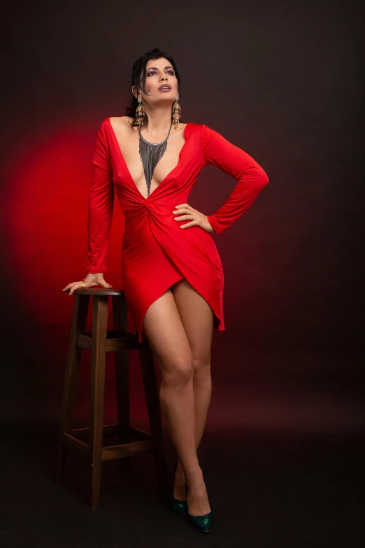 a woman in a red dress sitting on a stool, a portrait, pexels contest winner, low cut dress, intertwined full body view, eighties-pinup style, portrait of sherlyn chopra