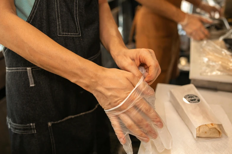 a person in an apron preparing food in a kitchen, bandage taped fists, aussie baristas, thumbnail, resin