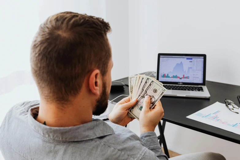 a man sitting in front of a laptop holding money, a colorized photo, pexels contest winner, 🚀🌈🤩, profile image, no - text no - logo, avatar image