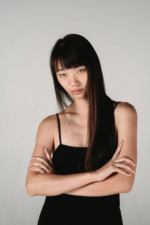 a woman in a black dress posing for a picture, inspired by Kim Tschang Yeul, trending on pexels, realism, wearing a tanktop, frown fashion model, portrait of a japanese teen, long straight black hair