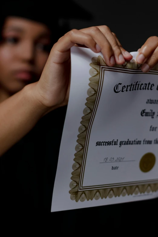 a woman holding a certificate in front of her face, documentary photo, digital image, graduation photo, ap news photo