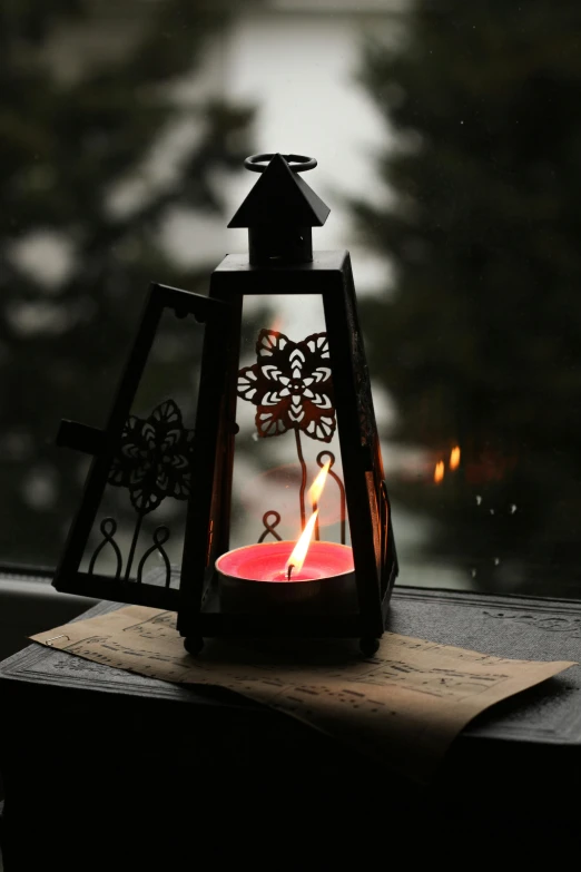 a lit candle sitting on top of a window sill, the lantern crown, on a dark winter's day, intricate story, lightweight
