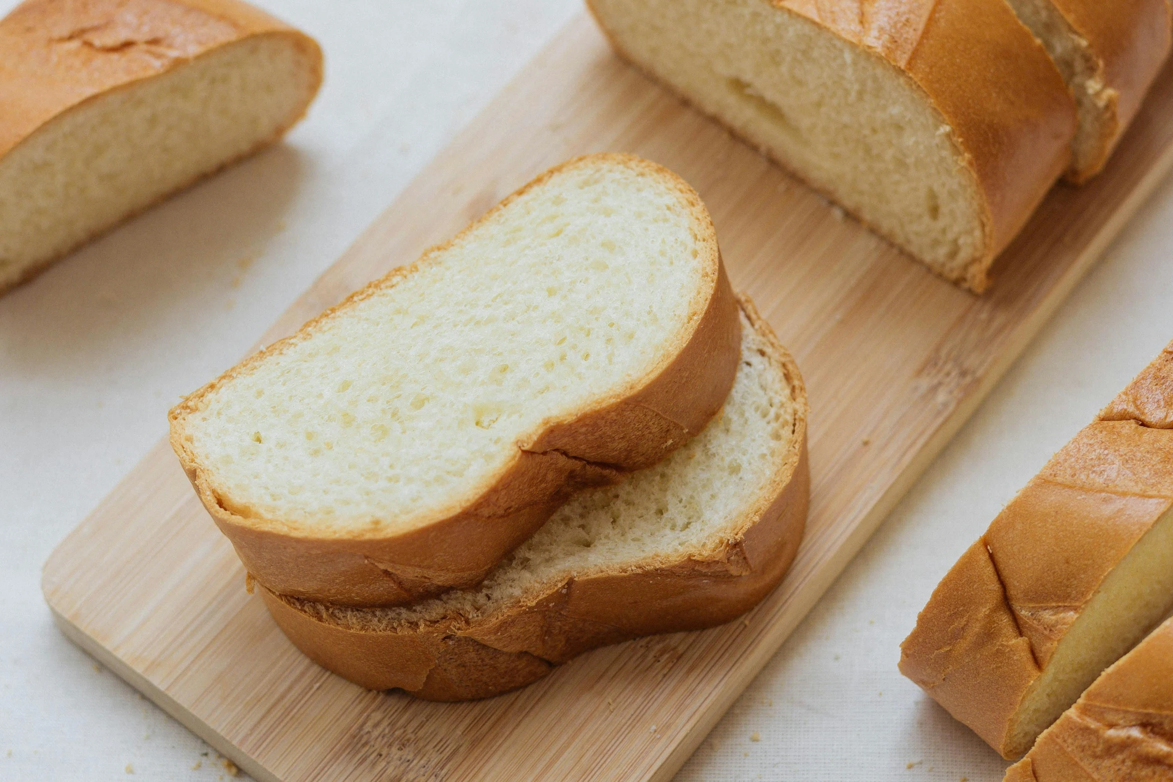 a loaf of bread sitting on top of a cutting board, beige, various sizes, white, bay area