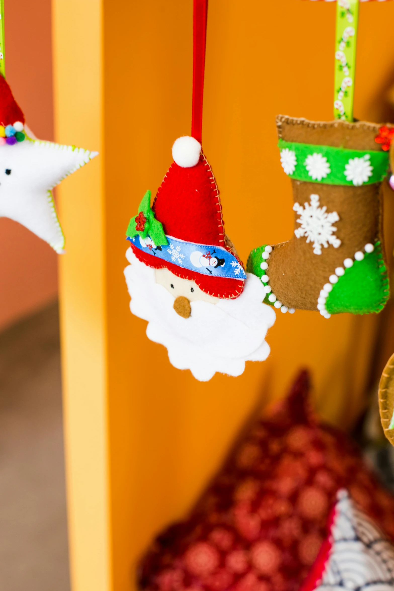 a close up of christmas decorations hanging on a wall, by Julia Pishtar, santa's workshop, thumbnail, multi - coloured