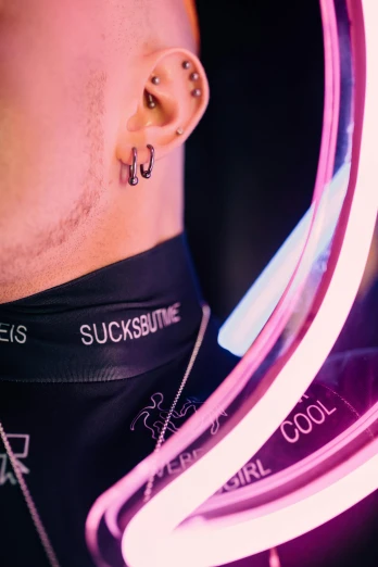 a close up of a person with ear piercings, an album cover, inspired by Seb McKinnon, trending on pexels, stuckism, in a cyberpunk themed room, neck shackle, highly reflective surface, rave outfit