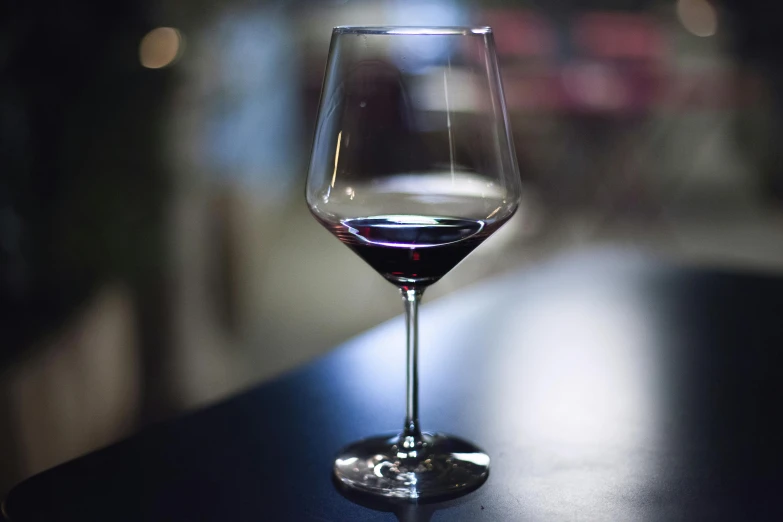 a glass of wine sitting on top of a table, pexels contest winner, realism, purple and red, angled, rectangle, dark undertones