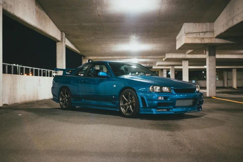 a blue car parked in a parking garage, inspired by Kanō Hōgai, pexels contest winner, hyperrealism, cobbled together nissan r34 gtr, ✨🕌🌙, full body 8k, garage kit
