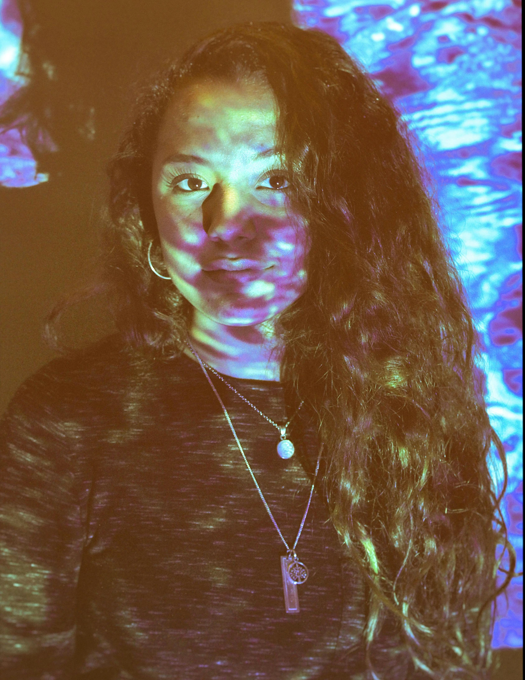 a close up of a person with long hair, inspired by Elsa Bleda, video art, iridescent lighting, looking happy, with haunted eyes and curly hair, promo image