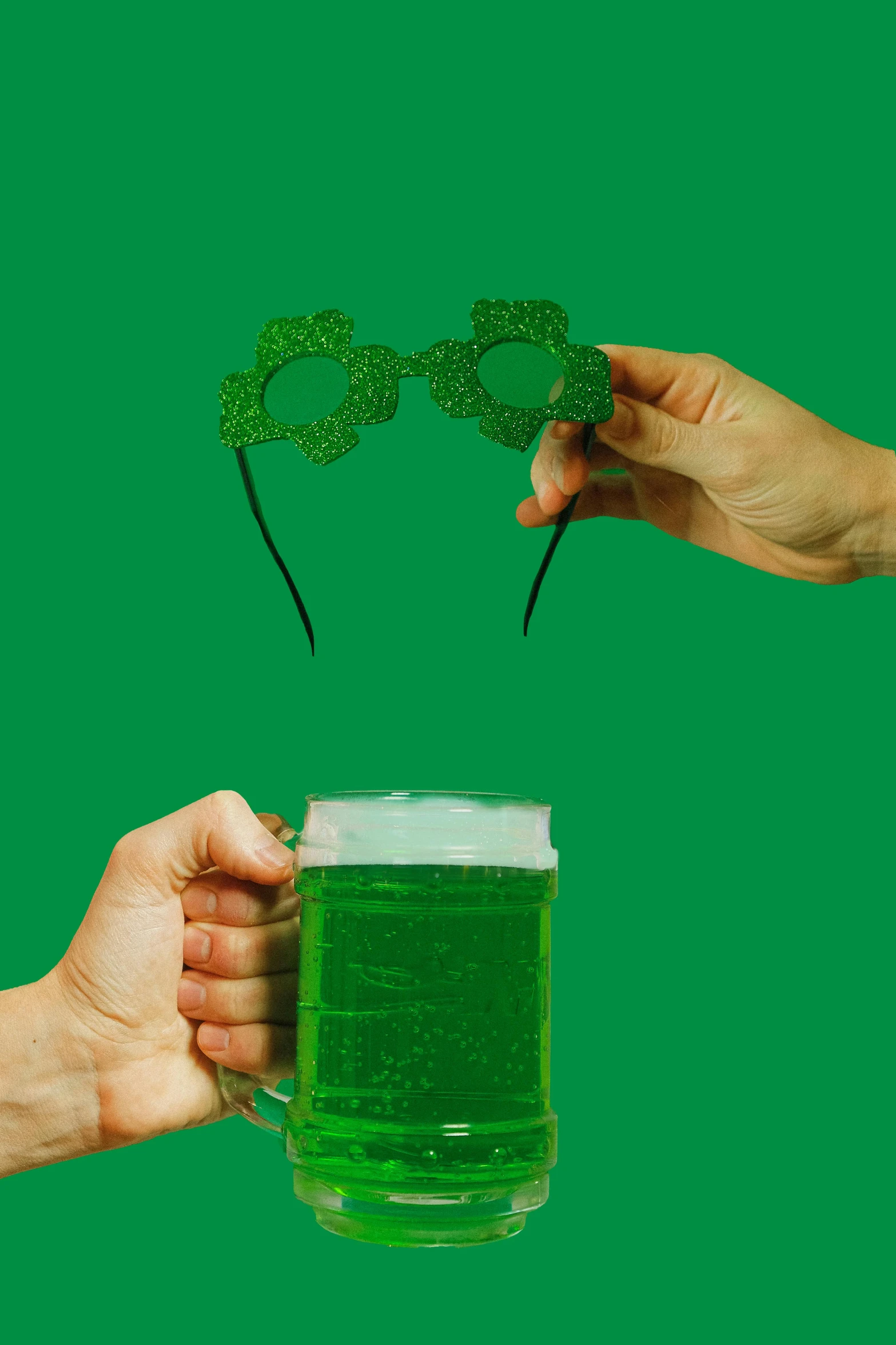 two hands holding a mug of green beer, a digital rendering, pexels, conceptual art, made of lasers, four leaf clover, glasses |, photobash