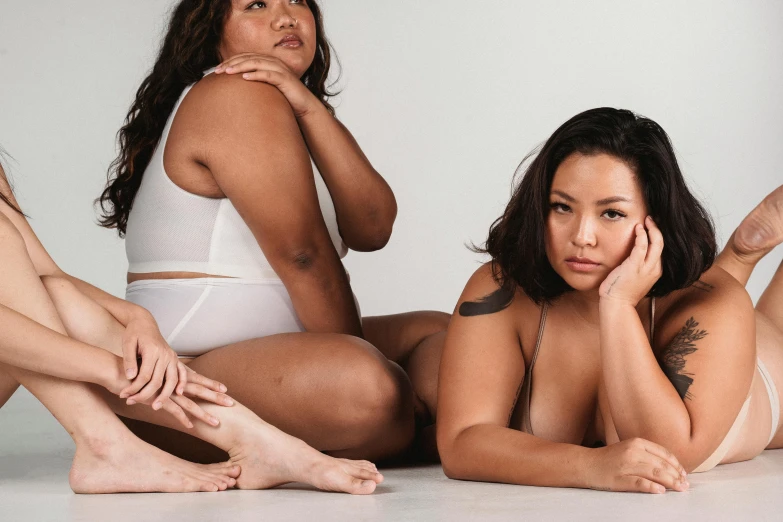 a group of women sitting next to each other, tanny skin, showing curves, two women, half asian