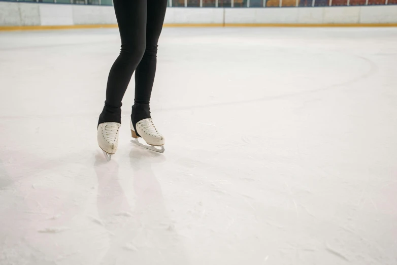 a woman is skating on an ice rink, by Meredith Dillman, trending on pexels, arabesque, close up to a skinny, tights, standing in an arena, plain background