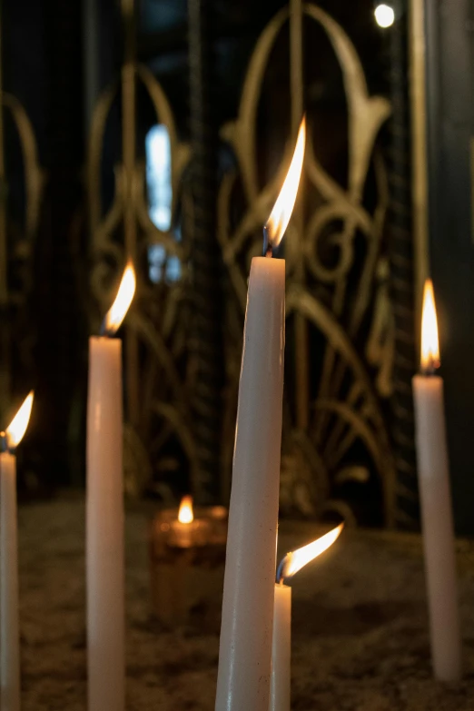 a group of white candles sitting on top of a table, profile image, inside the sepulchre, spire, sconces