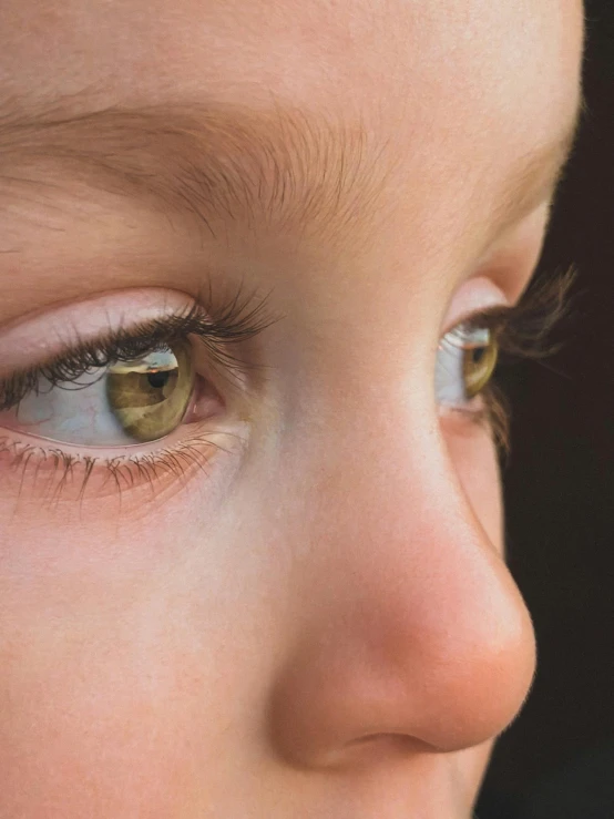 a close up of a young child's eyes, trending on unsplash, hyperrealism, soft light from the side, eyes are yellow, white detailed eyes, eye color green