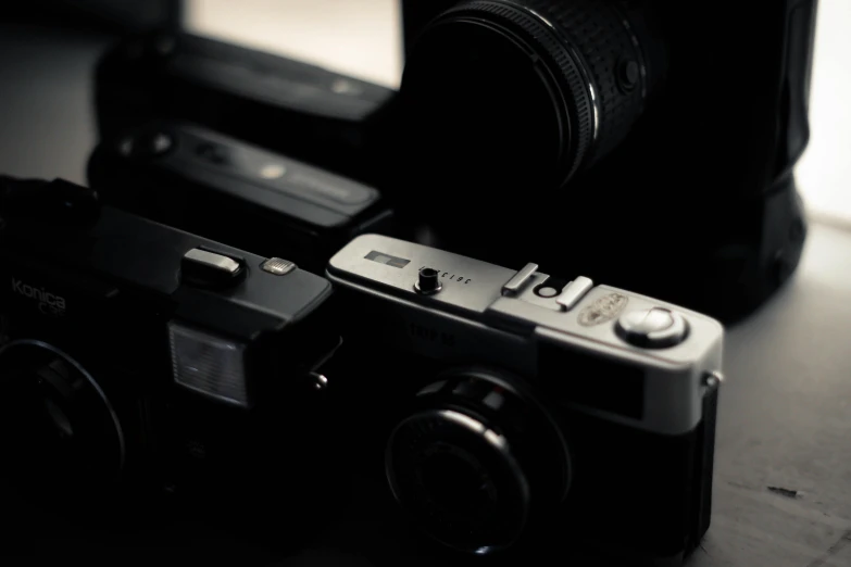 a couple of cameras sitting on top of a table, a picture, unsplash, fujifilm x100v, ((sharp focus))