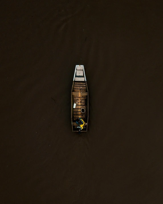 a small boat floating on top of a body of water, an album cover, by Jacob Toorenvliet, unsplash contest winner, black and brown colors, air shot, dark dingy, thumbnail