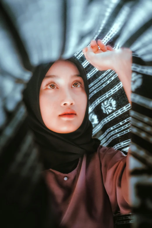 a woman in a hijab holding an umbrella, a picture, inspired by Bernardino Mei, unsplash contest winner, 🤤 girl portrait, indoor picture, glowy, gif