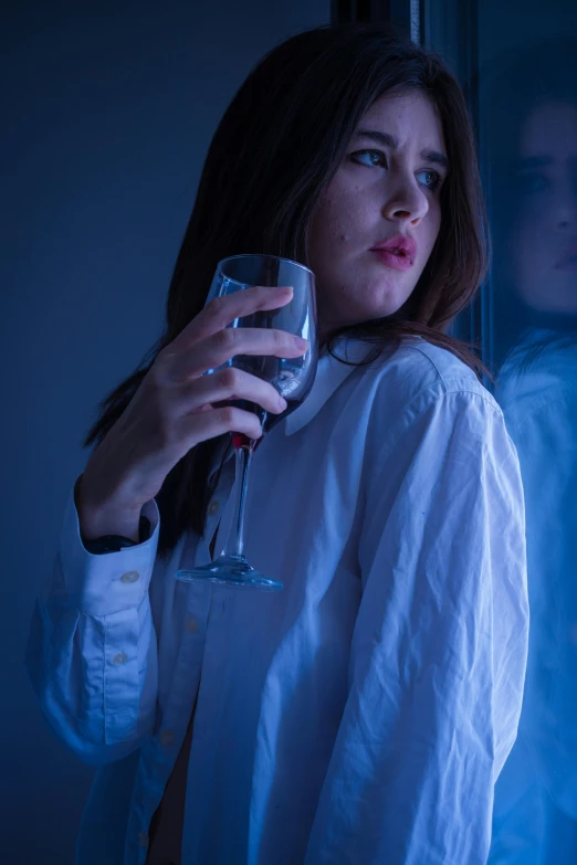 a woman holding a wine glass in front of a window, inspired by Nan Goldin, renaissance, iu lee ji-eun as a super villain, dramatic white and blue lighting, sad vampire, in white room