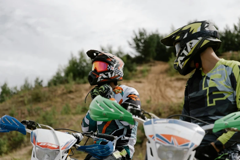 a couple of people that are on some dirt bikes, by Adam Marczyński, unsplash, figuration libre, with a kid, close-up photo, teaching, goggles