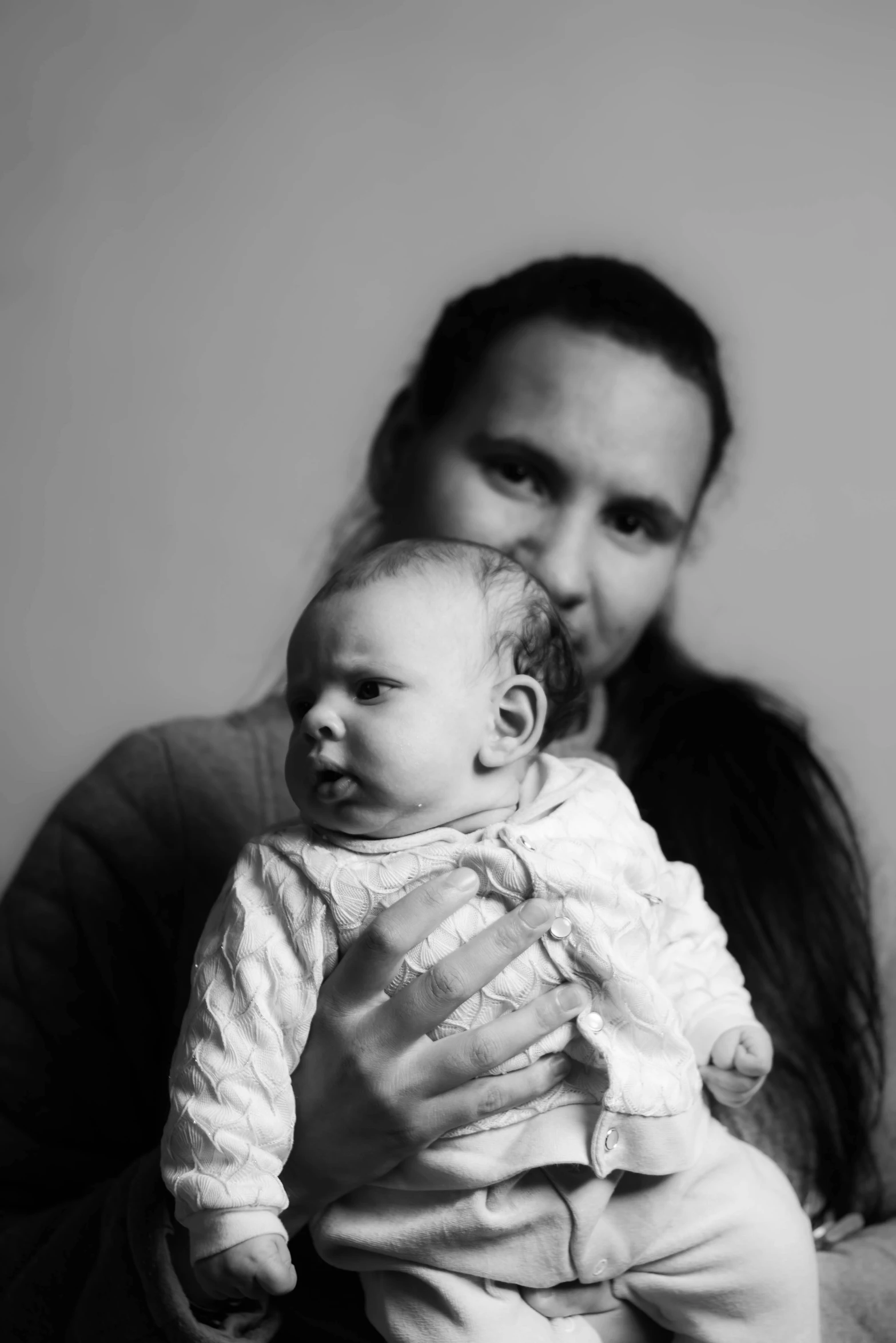 a man holding a baby in his arms, a black and white photo, by Anato Finnstark, aurora aksnes and zoë kravitz, aphex twin, ((portrait)), indigenous