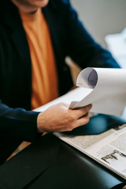 a man sitting at a table reading a paper, pexels contest winner, confidential documents, slick elegant design, selling insurance, large format