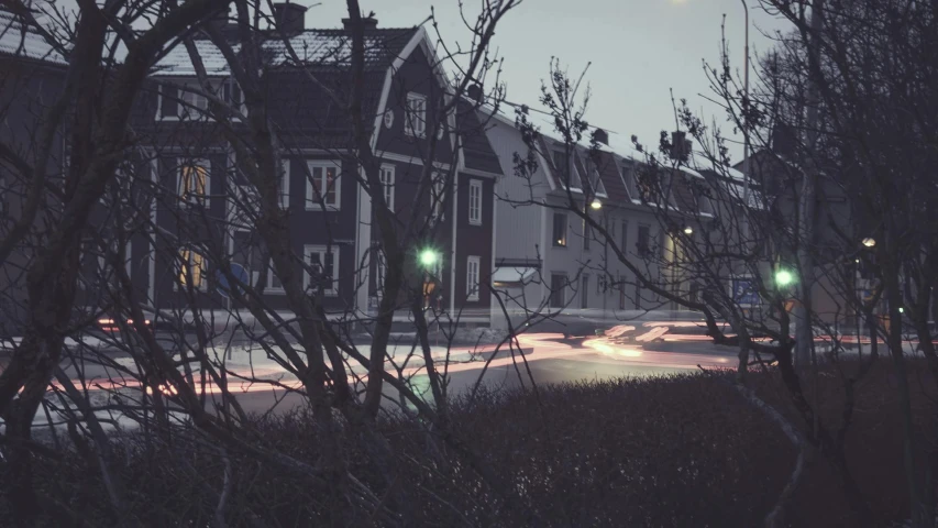 a street filled with lots of traffic next to tall buildings, by Karl Buesgen, pexels contest winner, location of a dark old house, in a suburb, hygge, grey