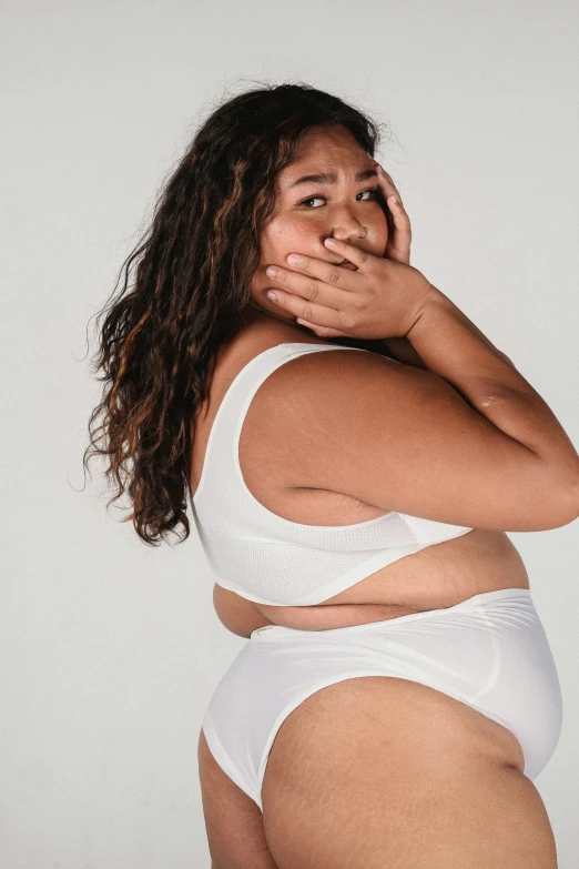 a woman in a white underwear posing for a picture, plus-sized, head bent back in laughter, whitespace, ad image