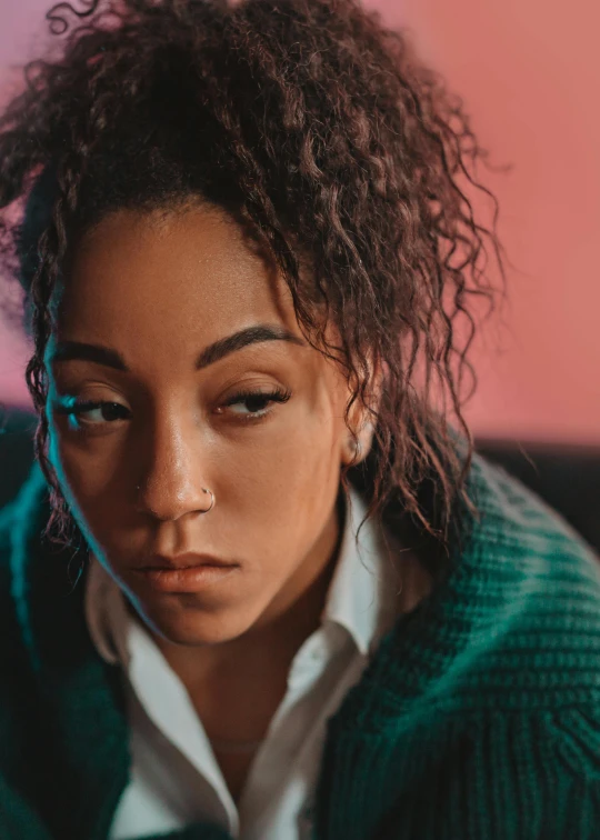 a woman with curly hair sitting on a couch, trending on pexels, hyperrealism, ashteroth, with a sad expression, portrait androgynous girl, teenage vanessa morgan