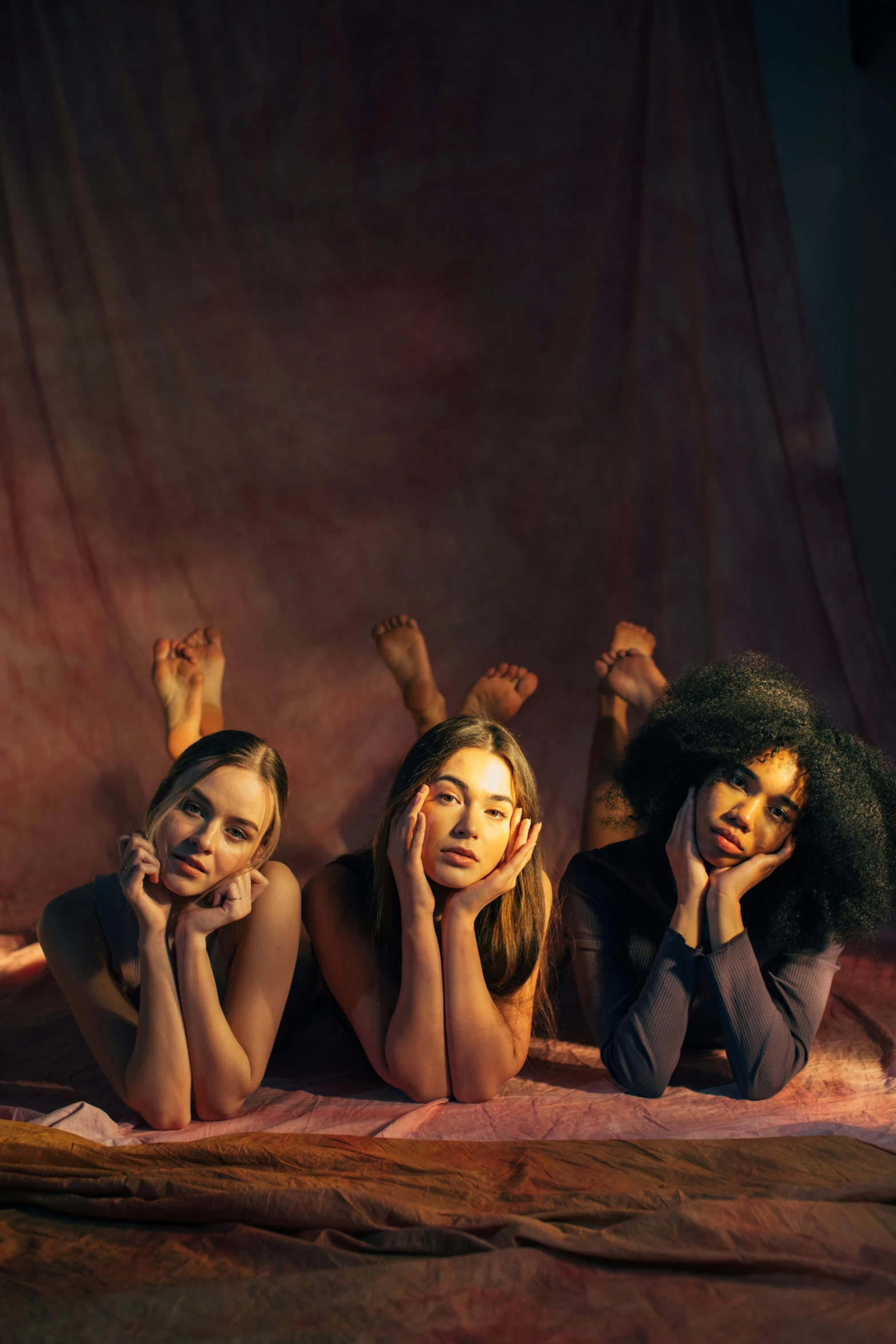 a group of women laying on top of a bed, an album cover, trending on pexels, renaissance, natural beauty expressive pose, sydney sweeney, three women, studio photo