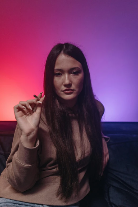 a woman sitting on a couch smoking a cigarette, an album cover, inspired by Elsa Bleda, trending on pexels, asian girl with long hair, rgb lights, russian girlfriend, rgb lighting