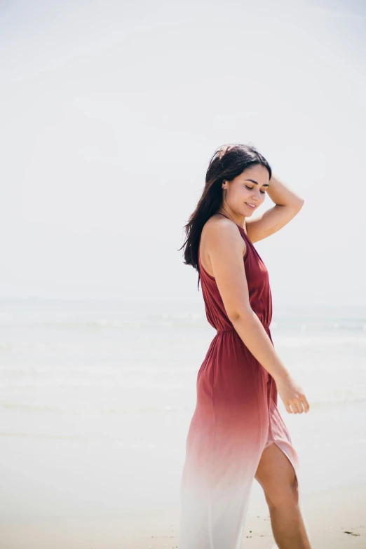 a woman standing on top of a beach next to the ocean, maroon red, ombre, wearing a sun dress, profile image