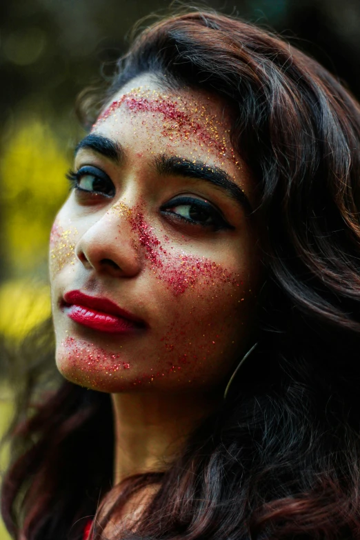 a woman with red paint on her face, pexels contest winner, glitter accents on figure, young himalayan woman, grainy, an attractive