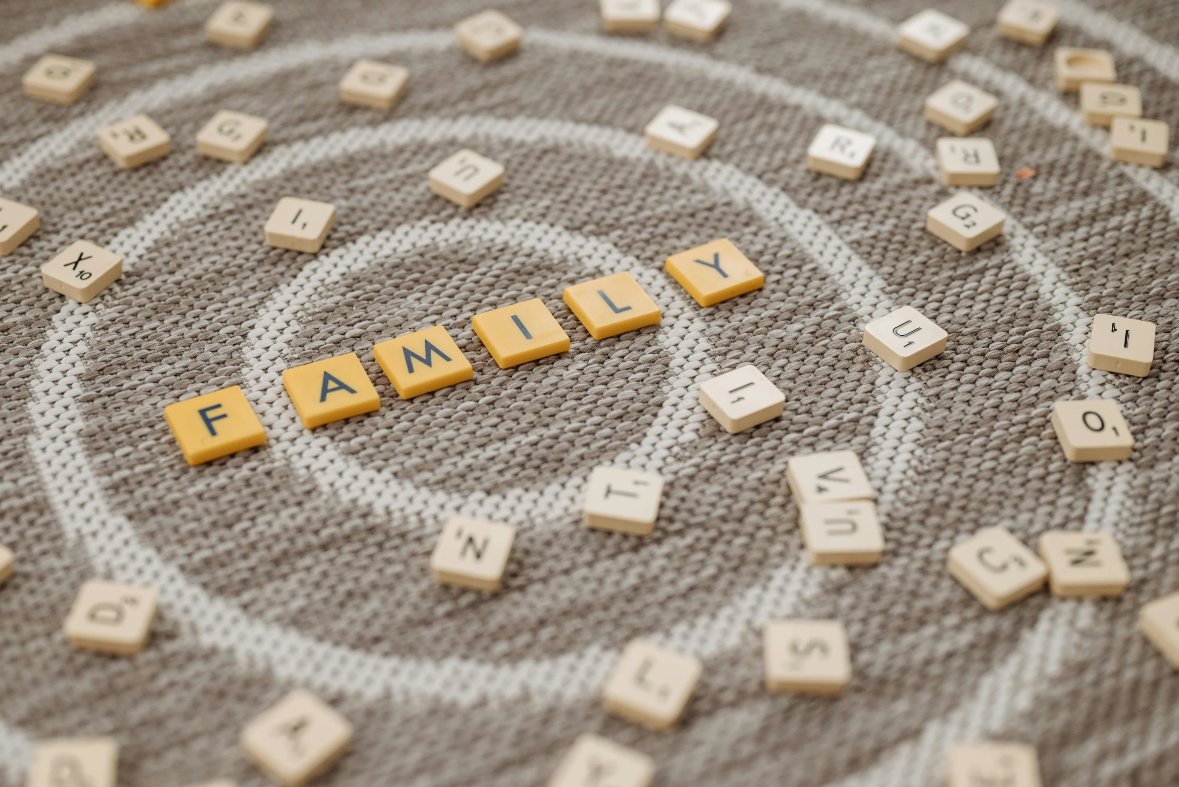 a circle of scrabbles with the word family spelled on them, ancestors, embroidery, connectedness, healthcare