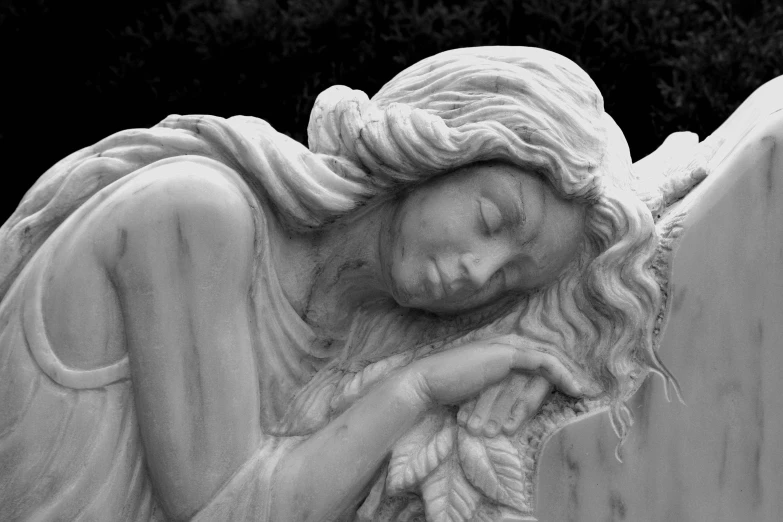 a black and white photo of a statue of an angel, a marble sculpture, inspired by Edward Robert Hughes, figurative art, portrait of a woman sleeping, mourning family, medium detail, made of marble