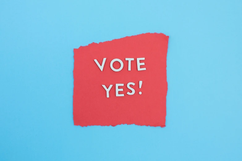 a red piece of paper with the word vote yes written on it, shutterstock contest winner, society 6, relaxed. blue background, ffffound, instagram post